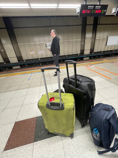 Petr s kufry na nástupišti