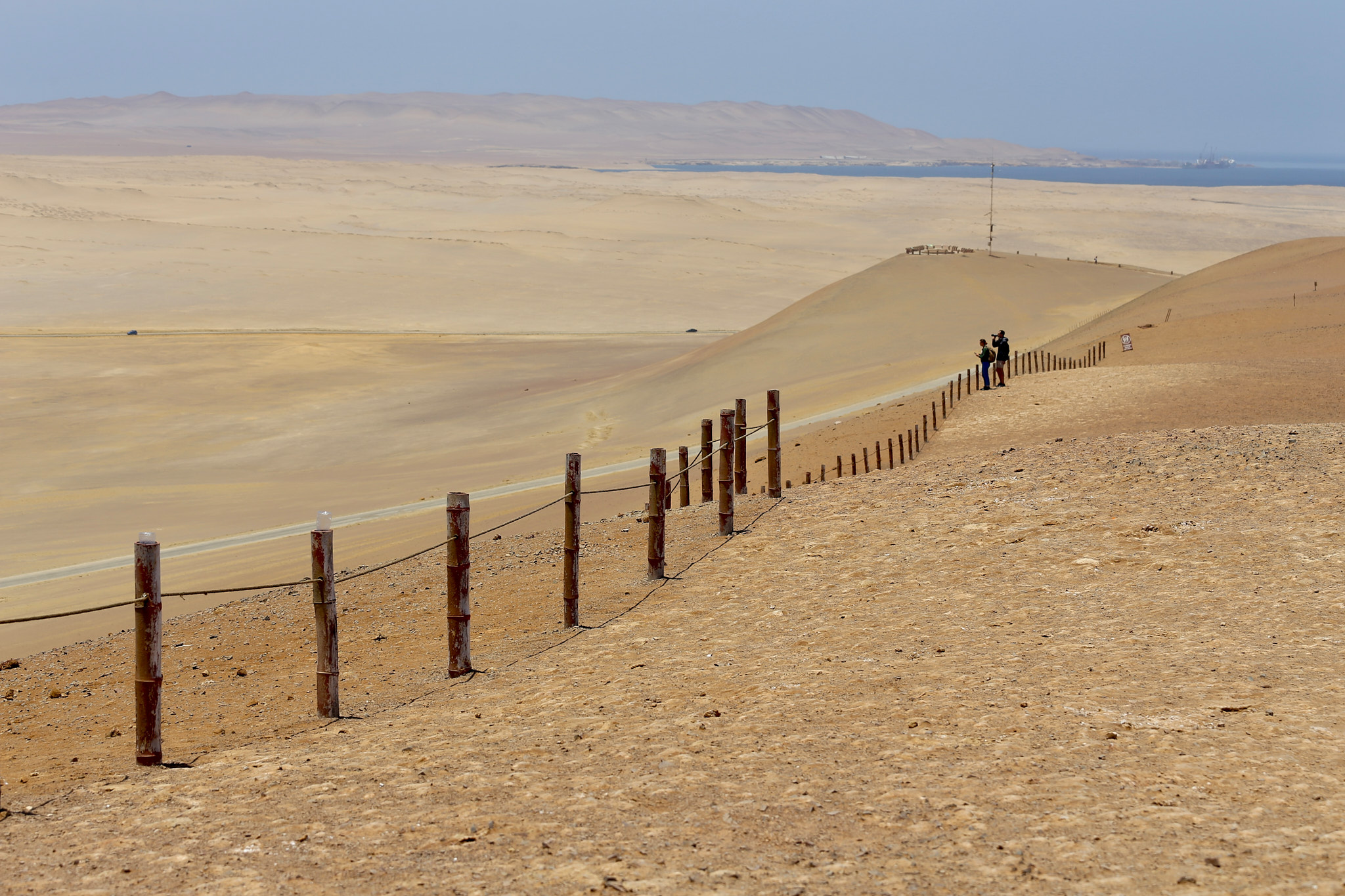 Turisté na vyhlídce za dřevěným plotem v poušti Paracas