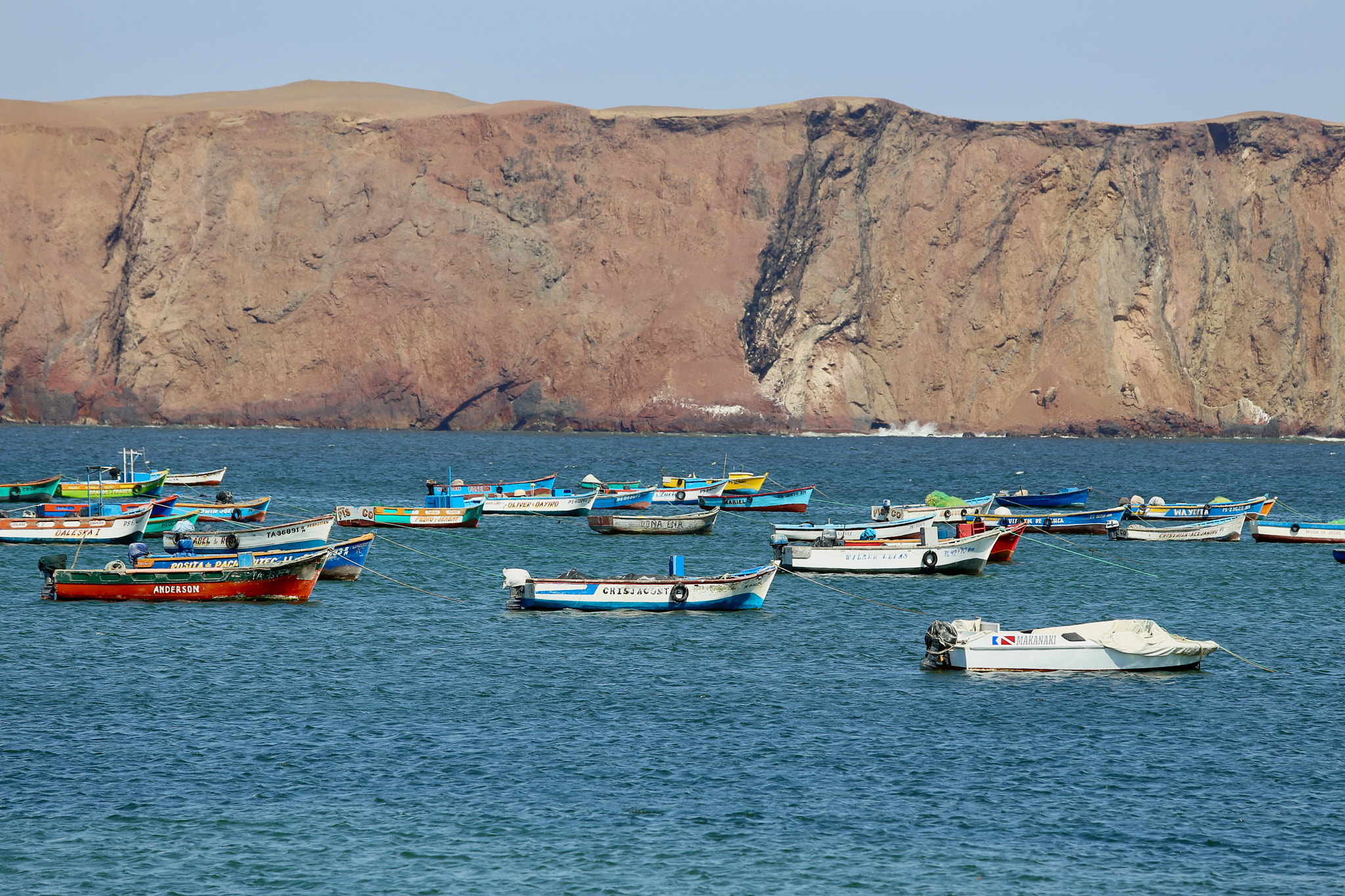Pestrobarevné rybářské lodičky v zátoce Bahía de Lagunillas v rezervaci Paracas