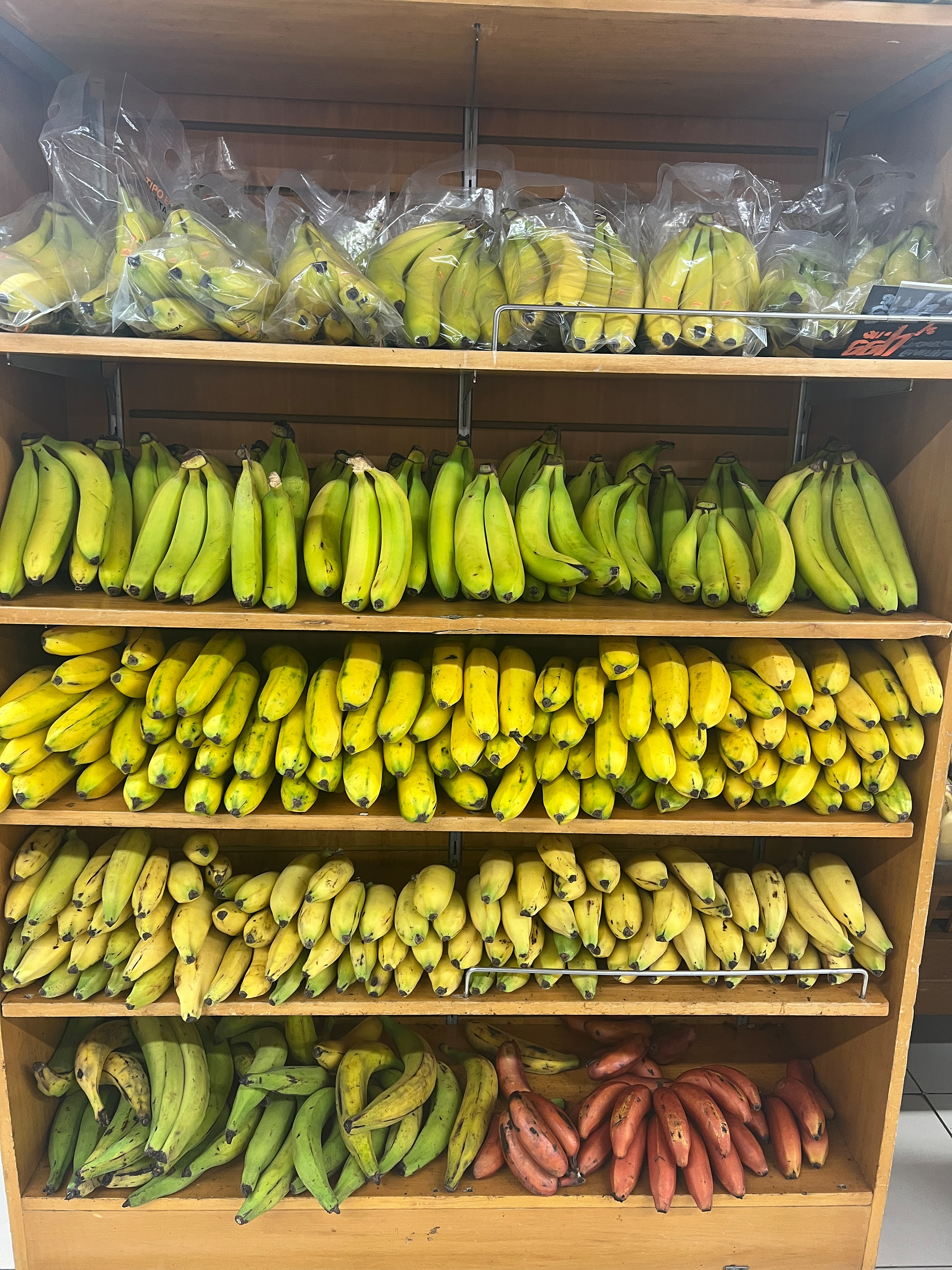 Police v supermarketu plné různých druhů banánů – žluté, zelené, červené a miniaturní