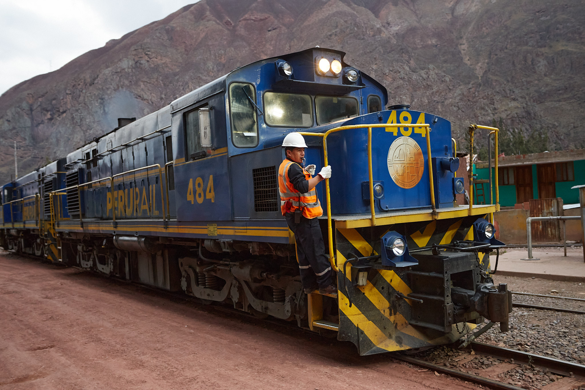 Modrá lokomotiva PeruRail číslo 484 na nádraží Pachar s průvodčím